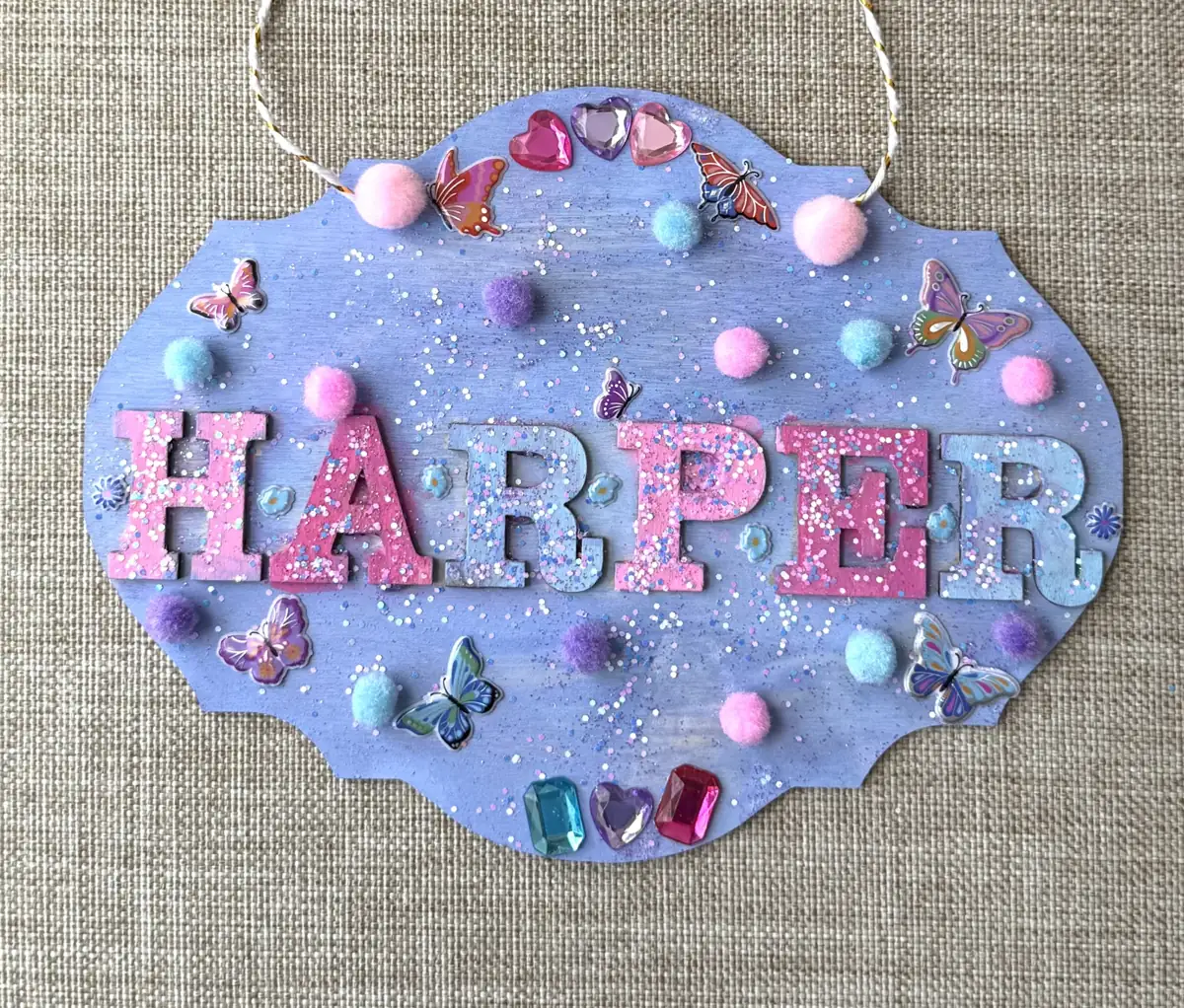 Actual completed HARPER butterfly name sign with colorful letters, gems, and decorations